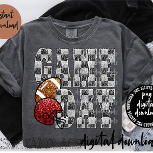 Könnte beinhalten: Dunkelgraues T-Shirt mit dem Schriftzug "GAME DAY" in einem schwarz-weißen Karomuster. Das Shirt hat auch einen Football und einen roten Glitzerhelm. Die Wörter "Sofort-Download" und "digitale Downloads" sind ebenfalls sichtbar.