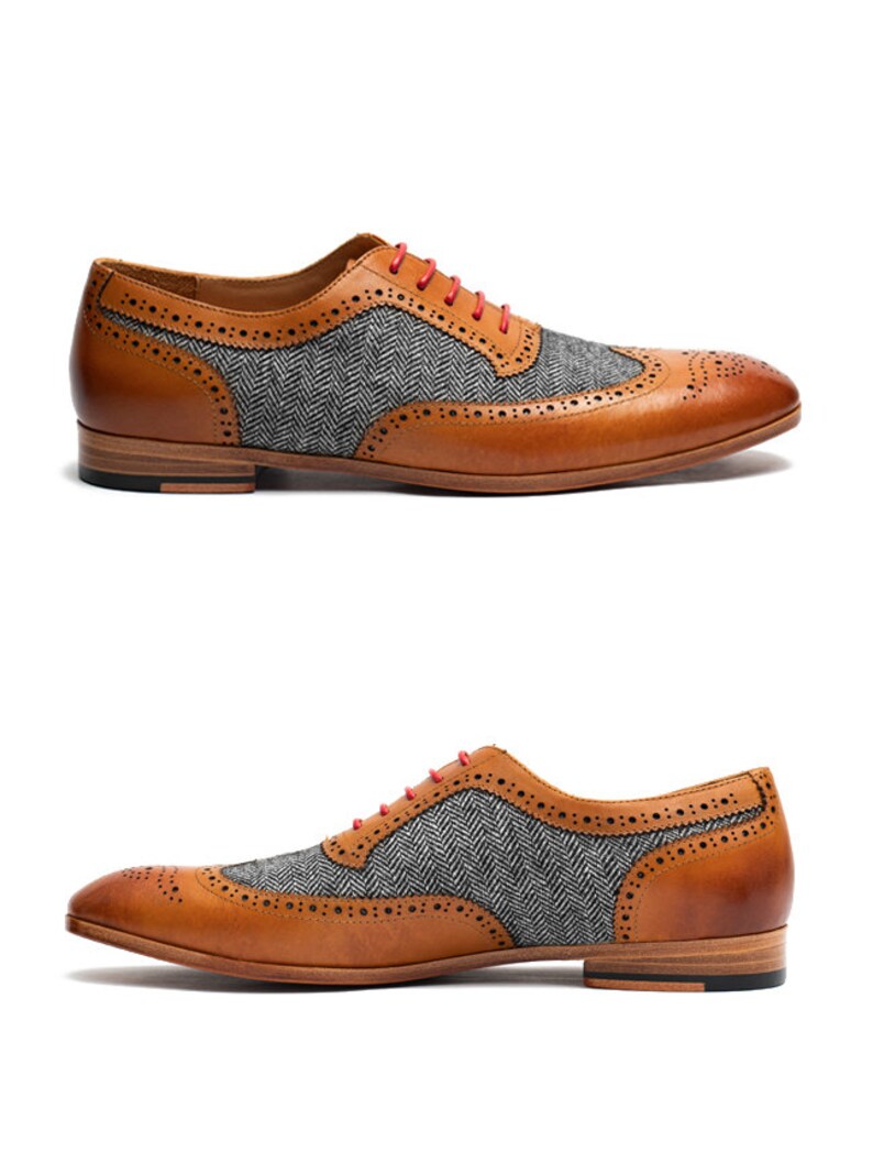 May include: Tan leather brogue shoes with a gray and black herringbone pattern on the toe and side panels. The shoes have red laces.