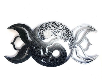 May include: A black and white yin yang symbol with a tree of life design inside. The symbol is surrounded by two crescent moons.