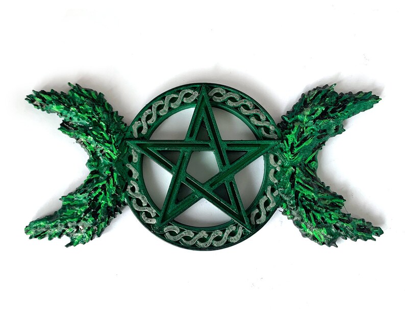 May include: A green pentagram with a triple moon symbol on either side. The pentagram is surrounded by a circle of Celtic knotwork.