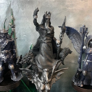 Puede incluir: Un conjunto de cuatro figuras impresas en 3D de color negro y plateado. Las figuras son de un guerrero, un lobo, una criatura alada y una persona con alas. Las figuras est&aacute;n sobre una base negra.
