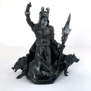 Puede incluir: Una figura impresa en 3D en blanco y negro de una figura m&iacute;tica con una larga barba y una corona, sosteniendo un bast&oacute;n y montando dos lobos.