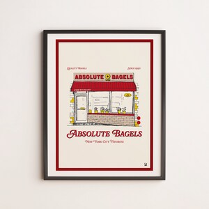 May include: A framed illustration of a red and yellow storefront with the text "Absolute Bagels" and the tagline "New York City Favorite".