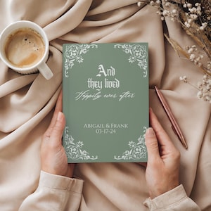 May include: A sage green wedding guest book with the text "And they lived Happily ever after" and the names Abigail & Frank, with the date 03-17-24. The book has decorative white floral corner designs.