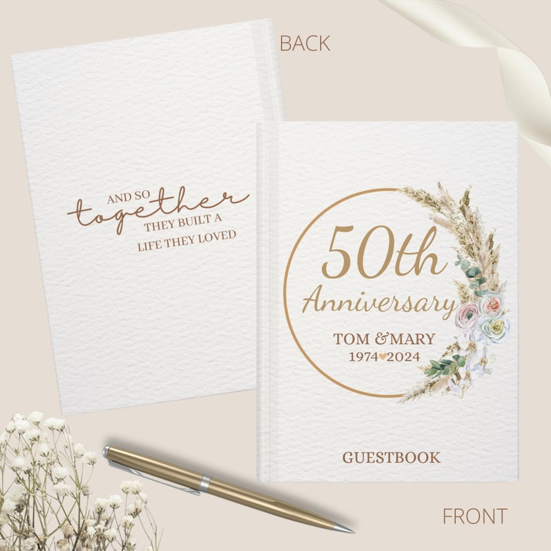 May include: A white guest book with a gold circle around the text "50th Anniversary" with a floral wreath and the text "Tom & Mary 1974 2024". The back of the book has the text "And so together they built a life they loved".