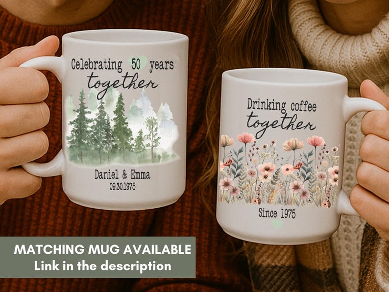 Może przedstawiać: Dwa białe ceramiczne kubki z uchwytami. Jeden kubek m&oacute;wi "Celebrating 50 years together" z leśną scenerią. Drugi m&oacute;wi "Drinking coffee together" z kwiatami. Oba kubki mają daty. Dostępny jest pasujący kubek.