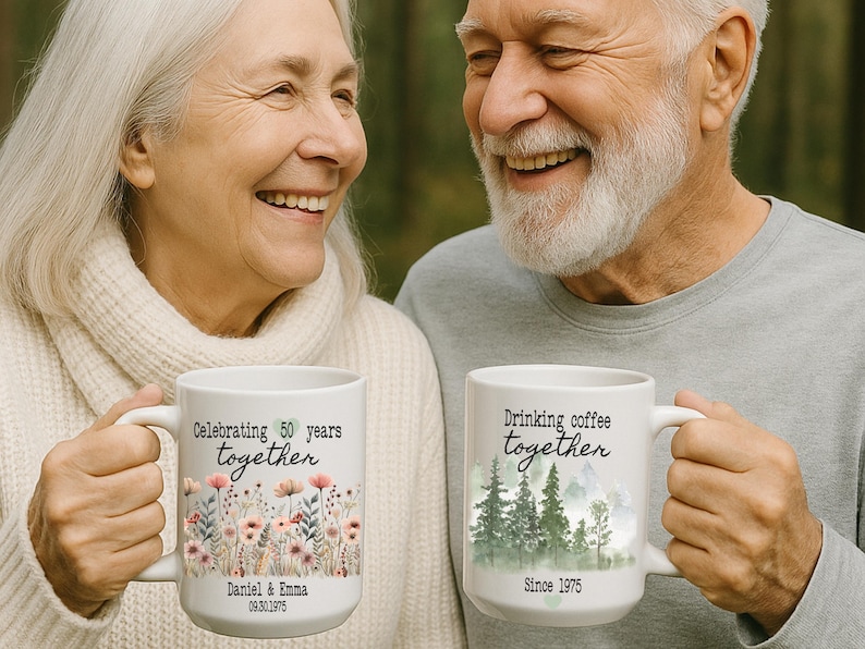 Może przedstawiać: Dwa białe ceramiczne kubki z uchwytami. Jeden kubek m&oacute;wi "Celebrating 50 years together" z kwiatowym wzorem i imionami. Drugi kubek m&oacute;wi "Drinking coffee together" ze sceną leśną i rokiem 1975.