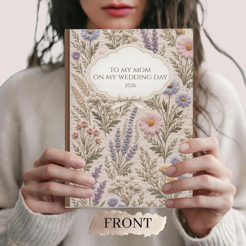 May include: A floral-patterned journal with the text "TO MY MOM ON MY WEDDING DAY 2026" in a decorative frame. The cover features a beige background with embroidered-style flowers in pink, purple, and blue. The word "FRONT" is at the bottom.