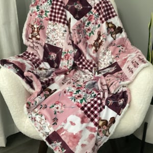 May include: A pink and burgundy patchwork fleece blanket with a floral and cowgirl theme. The blanket features a variety of patterns, including plaid, floral, and cowhide. The blanket is soft and cuddly, making it perfect for snuggling up on the couch.
