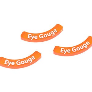 May include: Three orange, curved objects with the text "Eye Gouge" in white lettering. The objects are arranged on a white background. The text is centered on each object.