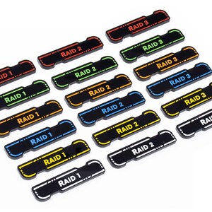 Könnte beinhalten: Ein Satz von 18 Spielmarken aus Kunststoff mit schwarzem Hintergrund und farbigem Text. Die Marken sind mit "RAID 1", "RAID 2" und "RAID 3" in verschiedenen Farben beschriftet.