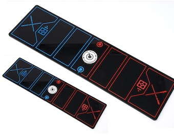 May include: Two black rectangular game boards with red and blue lines and markings. The boards have a white circular token with a black star in the center. The boards are for a game.