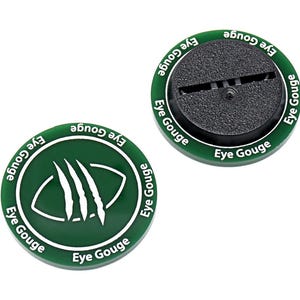 May include: Two green and black circular objects with the text "Eye Gouge" in white. One object has a graphic of a claw and eye, the other has a black textured center with a slot.