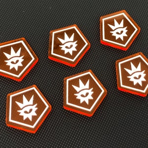 May include: Six orange hexagonal game pieces with a white eye and crown design.