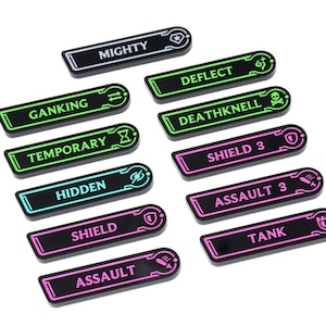 May include: A collection of black rectangular game tokens with glowing neon edges and white or neon text. The tokens include words like "MIGHTY", "DEFLECT", "SHIELD 3", and "ASSAULT 3".