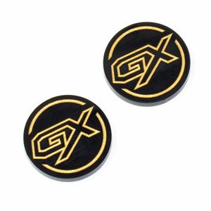 May include: Two black round buttons with a gold GX logo. The logo is a stylized letter G with an X through it.