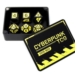 May include: A black rectangular dice box with a matching lid featuring the yellow text CYBERPUNK TCG DICE BOX. Inside the open box are six black polyhedral dice with yellow numbers, including a four-sided, six-sided, eight-sided, ten-sided, twelve-sided, and twenty-sided die.