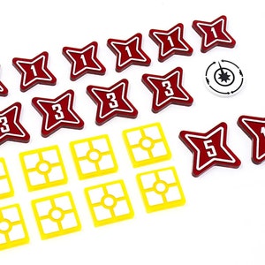 Peut inclure: Un ensemble de jetons rouges en forme d'étoile avec les numéros 1, 3, 5 et 10. Il y a aussi des jetons carrés jaunes avec un cercle au centre. Il y a un jeton blanc avec une étoile noire et une flèche noire.