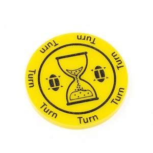 May include: Yellow round game piece with a black hourglass and footballs, and the word "Turn" repeated around the edge.