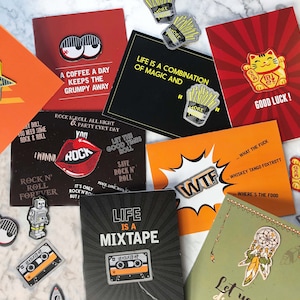 Può includere: Una collezione di cartoline colorate con vari disegni e detti. Le cartoline presentano una varietà di temi, tra cui rock and roll, buona fortuna e la vita è una mixtape. Ci sono anche diversi spille e toppe con diversi disegni, tra cui una stella, un gatto e un nastro per cassette.