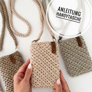 Könnte beinhalten: Gehäkelte Handyhüllen in verschiedenen neutralen Farben, jeweils mit passendem Gurt. Die Hüllen haben ein strukturiertes, diagonales Stichmuster und ein kleines Lederetikett. Der Text "ANLEITUNG HANDYTASCHE" ist enthalten.