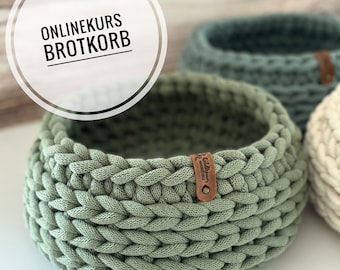 Puede incluir: Cesta de pan de crochet verde con una etiqueta de cuero marrón que dice "Handmade with love".