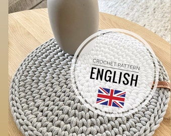 May include: A gray crochet coaster with a white circle around it that says "Crochet Pattern English" with a UK flag inside the circle.