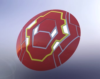 May include: A red and yellow circular shield with a geometric design. The shield has a raised, textured surface.