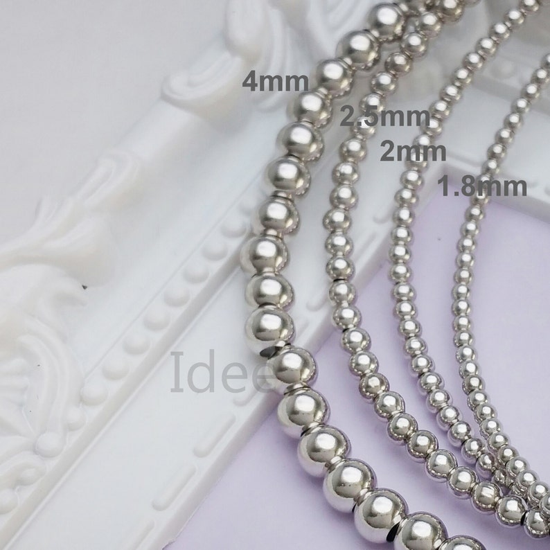May include: Four strands of silver bead necklaces with different sized beads. The beads measure 1.8 mm, 2 mm, 2.5 mm, and 4 mm in diameter.