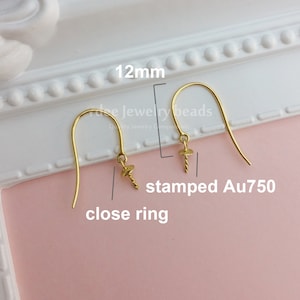 May include: Gold earring hooks with a screw-on closure and a close ring. The hooks are 12 mm long and are stamped Au750.