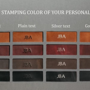 May include: A grid of sixteen rectangular leather swatches in four shades of brown and black, each embossed with the letters JBA. The columns display four stamping options: Milk text, Plain text, Silver text, and Gold text for personalization.