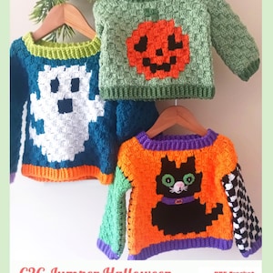 May include: Three crocheted jumpers on wooden hangers. One is teal with a white ghost, one is light green with an orange pumpkin, and one is orange with a black cat, purple trim, and a checkered sleeve. Text reads: C2C Jumper Halloween PDF Crochet Pattern By Baby Crochet Designs.