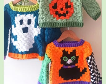 May include: Three crocheted jumpers on wooden hangers. One is teal with a white ghost, one is light green with an orange pumpkin, and one is orange with a black cat, purple trim, and a checkered sleeve. Text reads: C2C Jumper Halloween PDF Crochet Pattern By Baby Crochet Designs.