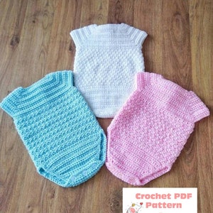 May include: Three crocheted baby onesies in white, light blue, and pink. The onesies have short sleeves and are made with a textured stitch. The text "Crochet PDF Pattern by BabyCrochetDesigns" is visible at the bottom of the image.