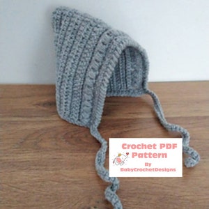 May include: Gray crocheted baby hat with long ties. Crochet PDF Pattern by BabyCrochetDesigns.