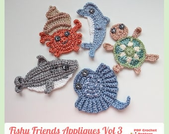 May include: Five crocheted sea creature appliques including a red crab with a shell, a blue dolphin, a green and tan sea turtle, a gray shark, and a blue stingray. The text Fishy Friends Appliques Vol 3 PDF Crochet Pattern is visible.