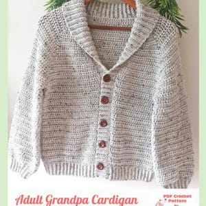 May include: A light grey speckled crochet cardigan featuring a shawl collar, long sleeves, and five dark brown buttons down the front. The text at the bottom reads Adult Grandpa Cardigan and PDF Crochet Pattern By Baby Crochet Designs.