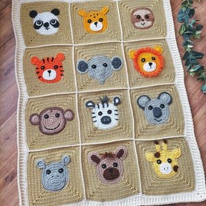 Peut inclure: Une couverture b&eacute;b&eacute; en crochet avec un fond beige et une bordure blanche. La couverture pr&eacute;sente 12 visages d'animaux diff&eacute;rents, dont un panda, un tigre, un &eacute;l&eacute;phant, un singe, un z&egrave;bre, un koala, une girafe et un hippopotame.