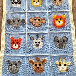Peut inclure: Une couverture pour b&eacute;b&eacute; en crochet bleu et blanc avec diff&eacute;rents visages d'animaux, dont un panda, un singe, un lion, un z&egrave;bre, un tigre, un hippopotame, une girafe et un ours.
