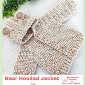 May include: A beige crochet hooded jacket featuring two small bear ears on the hood and five light brown wooden buttons down the front. The text Bear Hooded Jacket and PDF Crochet Pattern by Baby Crochet Designs is visible.