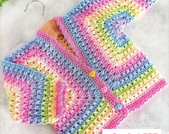 May include: A rainbow crochet cardigan with heart-shaped buttons. The cardigan is made with a variety of colors, including pink, blue, green, and yellow. Crochet PDF Pattern by BabyCrochetDesigns.