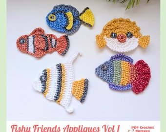 May include: Five crocheted fish appliques in various colors and patterns, including a blue tang, orange clownfish, yellow pufferfish, striped angelfish, and a rainbow fish. The text reads Fishy Friends Appliques Vol 1 PDF Crochet Pattern.