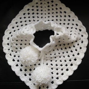 K&ouml;nnte beinhalten: Wei&szlig;er H&auml;kel-Schal mit gewelltem Rand und zwei wei&szlig;en Bommeln.