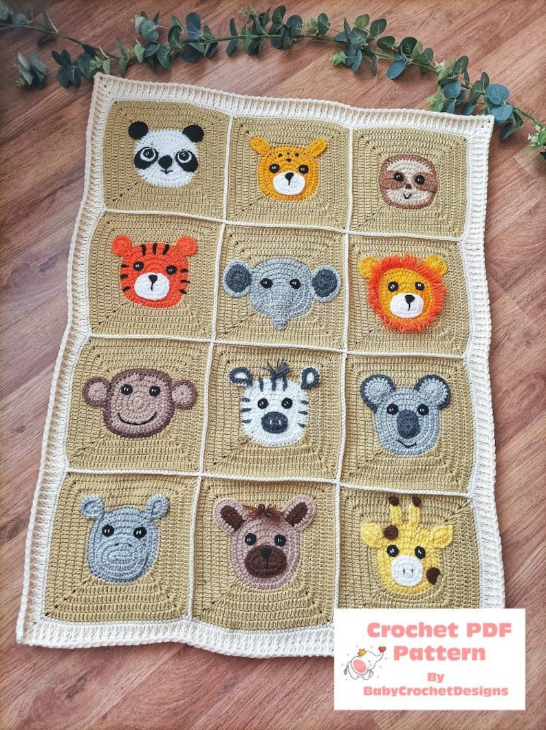Peut inclure: Une couverture b&eacute;b&eacute; en crochet avec un motif de diff&eacute;rents visages d'animaux. La couverture est de couleur beige avec une bordure blanche. Les animaux incluent un panda, un tigre, un lion, un singe, un z&egrave;bre, un koala, un hippopotame et une girafe.