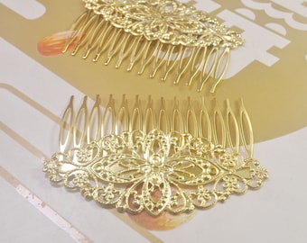 Op de afbeelding: Twee gouden haar kammen met ingewikkelde bloemmotieven. De kammen hebben een delicaat, filigraan patroon en zijn perfect om elke haarstijl een vleugje elegantie te geven.
