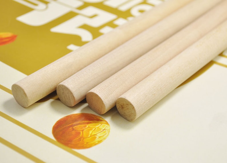 Puede incluir: Cuatro clavijas de madera, todas del mismo tama&ntilde;o, est&aacute;n apiladas una encima de la otra. Las clavijas son de color marr&oacute;n claro y tienen un acabado liso y pulido.