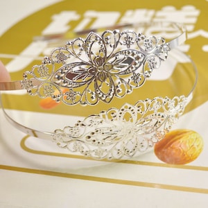 Peut inclure: Un serre-tête argenté avec un motif floral délicat. Le serre-tête est en métal et possède une bande fine et flexible.