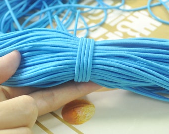 May include: A close-up of a bundle of light blue elastic string. The string is soft and stretchy, and it is perfect for crafting projects.