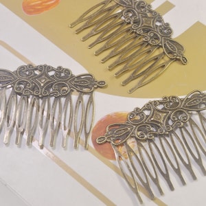 Puede incluir: Tres peines para el cabello de color dorado antiguo con intrincados diseños de filigrana. Cada peine tiene una parte superior decorativa y una fila de dientes.