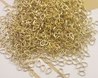 May include: A large pile of gold-colored metal teardrop-shaped pendant bails. The bails are small and delicate, and they are perfect for adding a touch of elegance to any jewelry project.